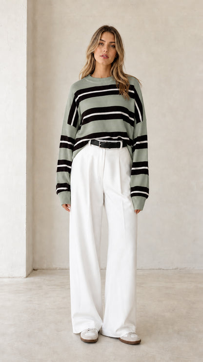 Front view of woman wearing sage green striped long sleeve knit sweater