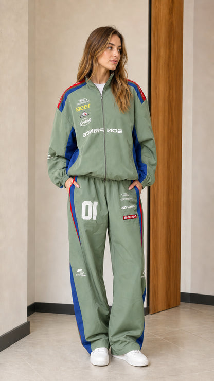 Front view of woman wearing sage green colorblock racing two-piece tracksuit set