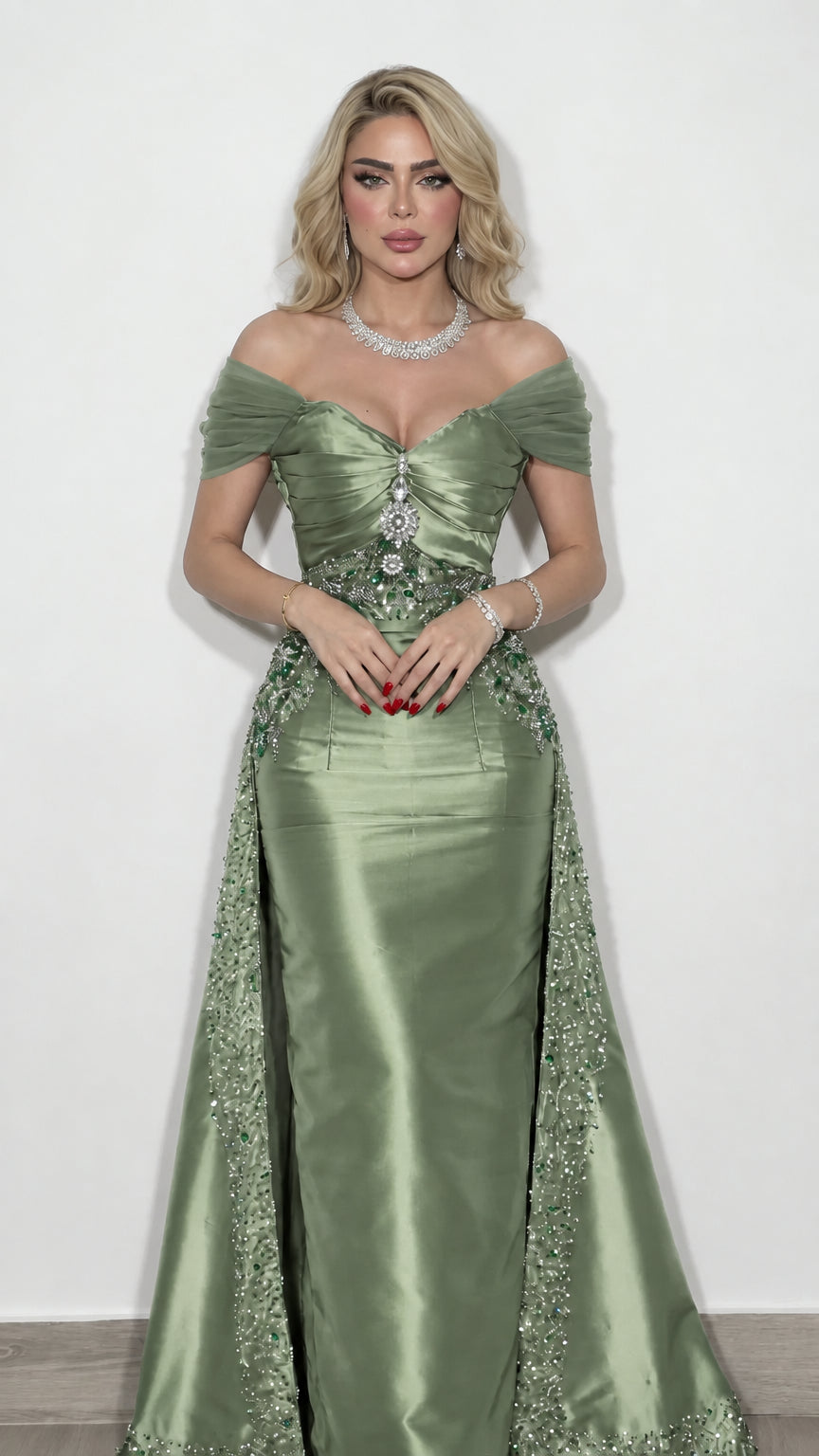 Model wearing sage green satin formal gown with intricate beading and side overskirt