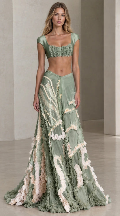 Front view of model wearing sage green two-piece satin crop top and ruffle maxi skirt