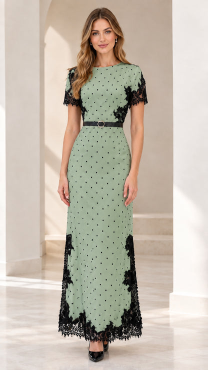 Model wearing sage green polka dot maxi dress with black lace trim and belt