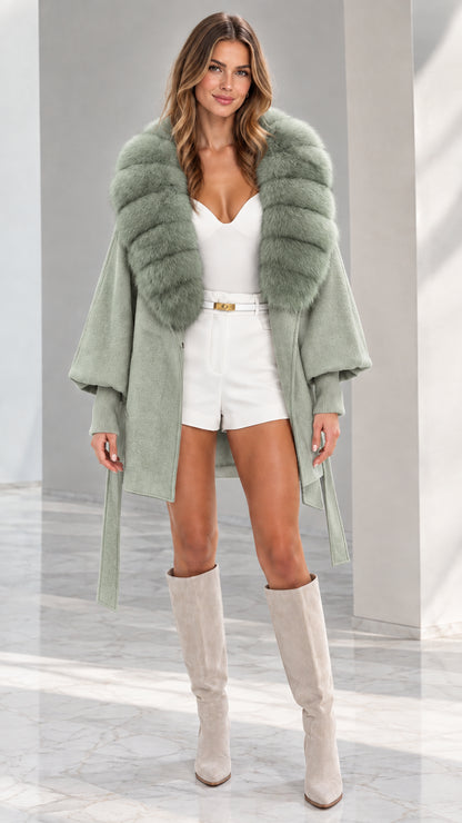 Front view of woman wearing Sage Green faux fur collar belted cape coat