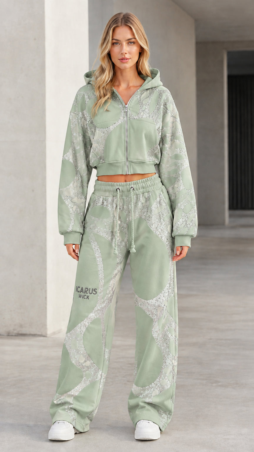 Front view of model wearing sage green graphic cropped zip hoodie and wide-leg sweatpants