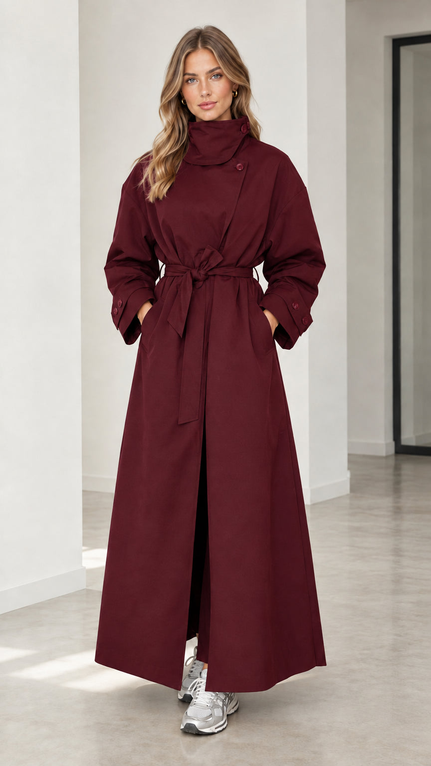Front full view of woman wearing burgundy wine red full-length high neck trench coat