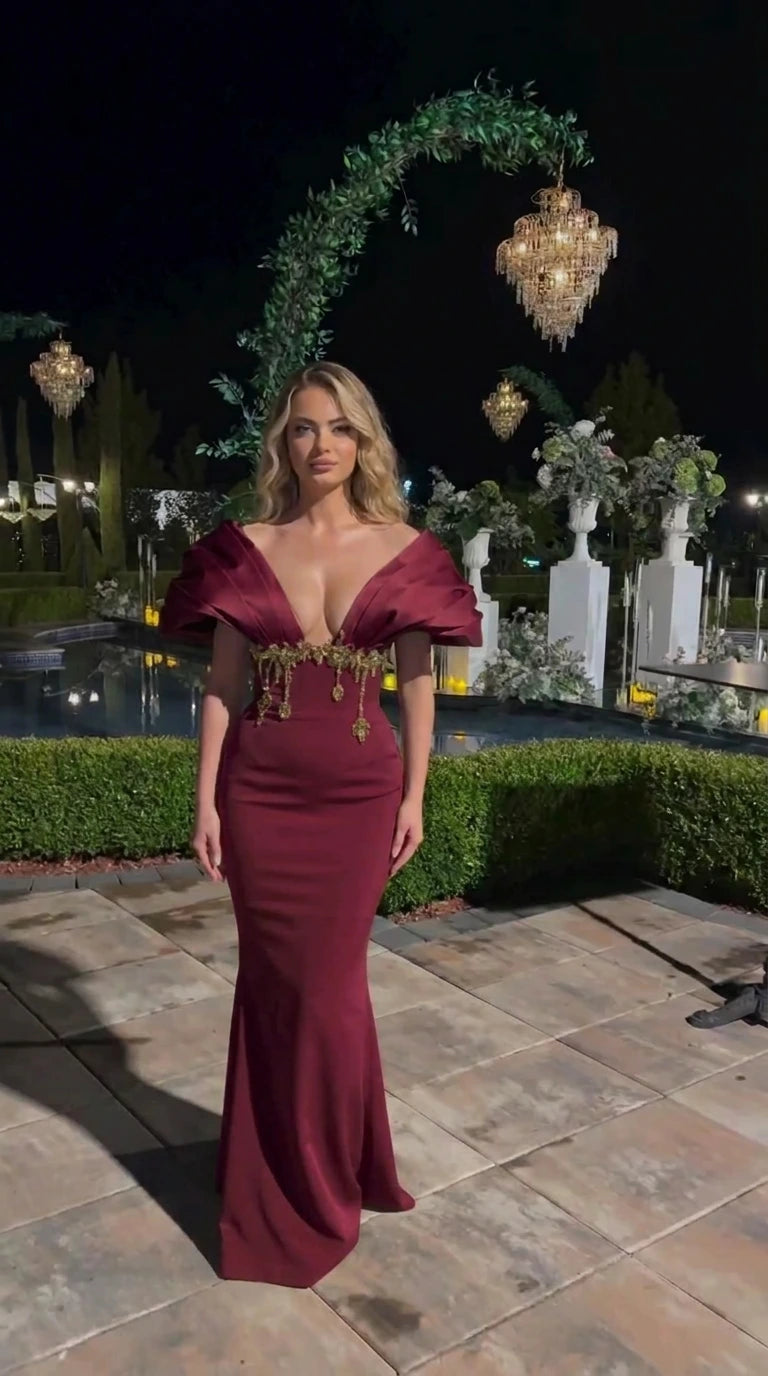 Full-length burgundy wine formal evening gown with sculpted shoulders and embellished waist