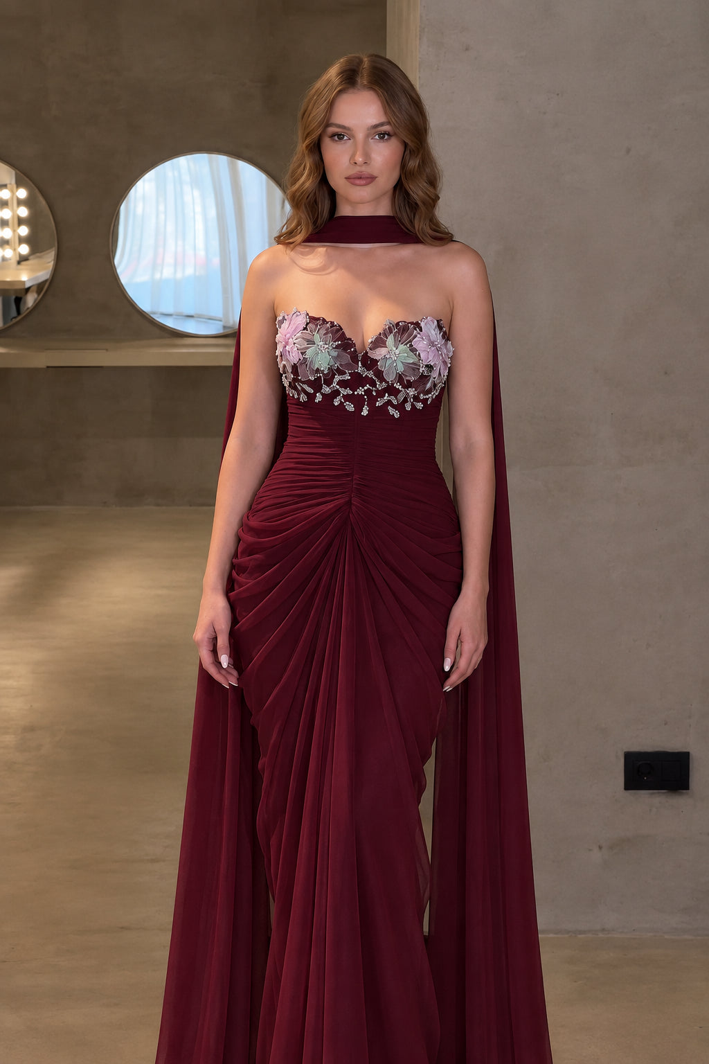 Front view of burgundy red sweetheart formal maxi dress with cape