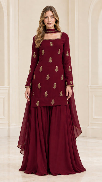 Model wearing deep maroon red embroidered kurta sharara suit set