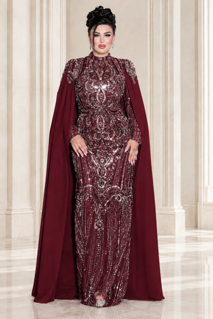 Model wearing burgundy red sequin embroidered formal cape gown