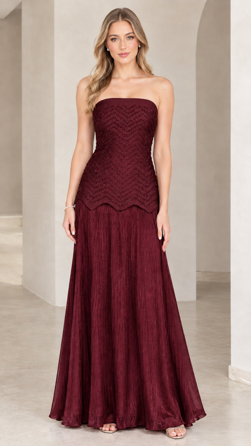 Full-length view of model in burgundy wine strapless beaded evening dress