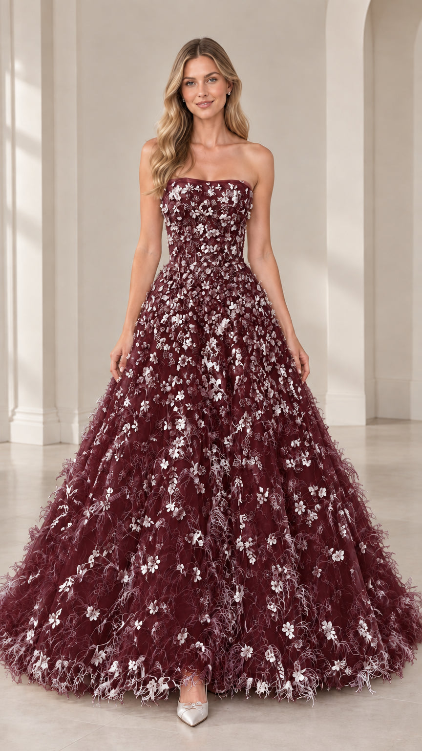 Model wearing strapless burgundy floral applique evening gown