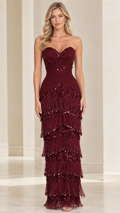 Front view of model wearing burgundy wine strapless tiered fringe evening dress