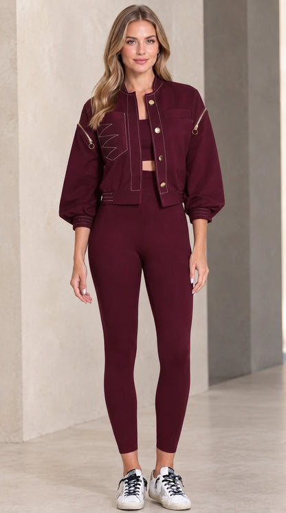 Model wearing burgundy cropped utility jacket paired with sports set