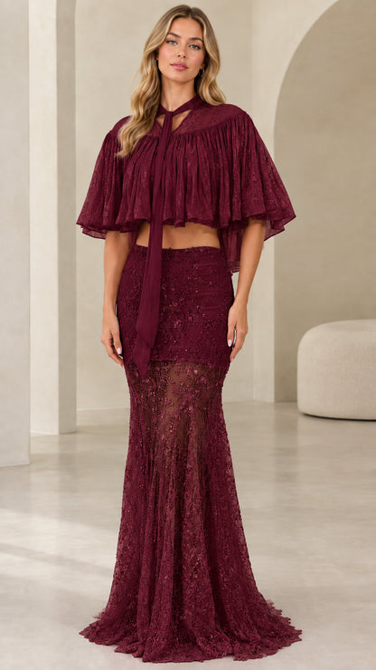 Model wearing burgundy wine sequined two-piece evening set with neck-tie capelet