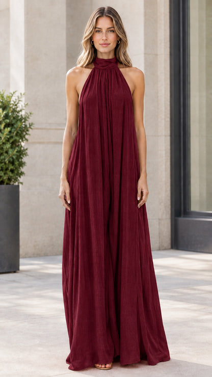 Front view of model wearing deep burgundy halter neck wide-leg jumpsuit