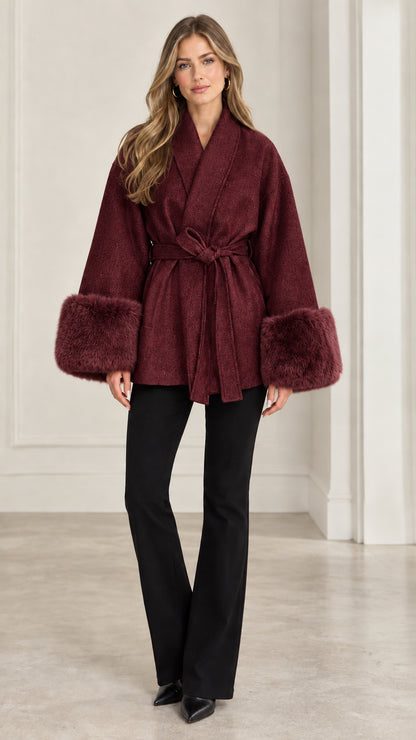 Front view of model wearing burgundy red wrap coat with matching faux fur cuffs
