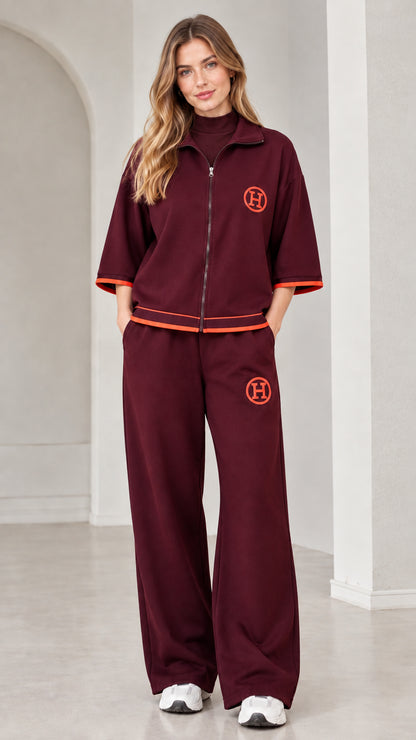Front view of woman wearing burgundy two-piece zip-up tracksuit set
