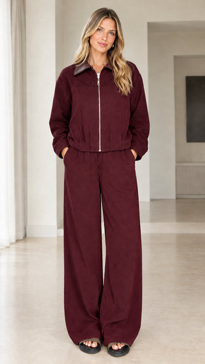 Front view of model wearing burgundy two-piece zip jacket and pants set