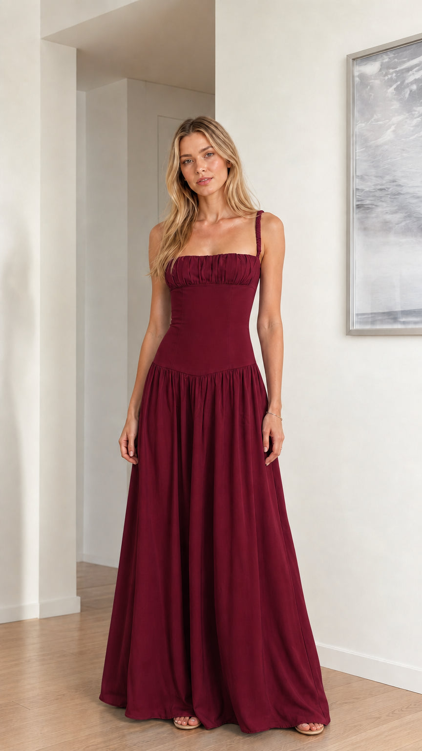 Model wearing rich burgundy ruched bust drop waist formal maxi dress
