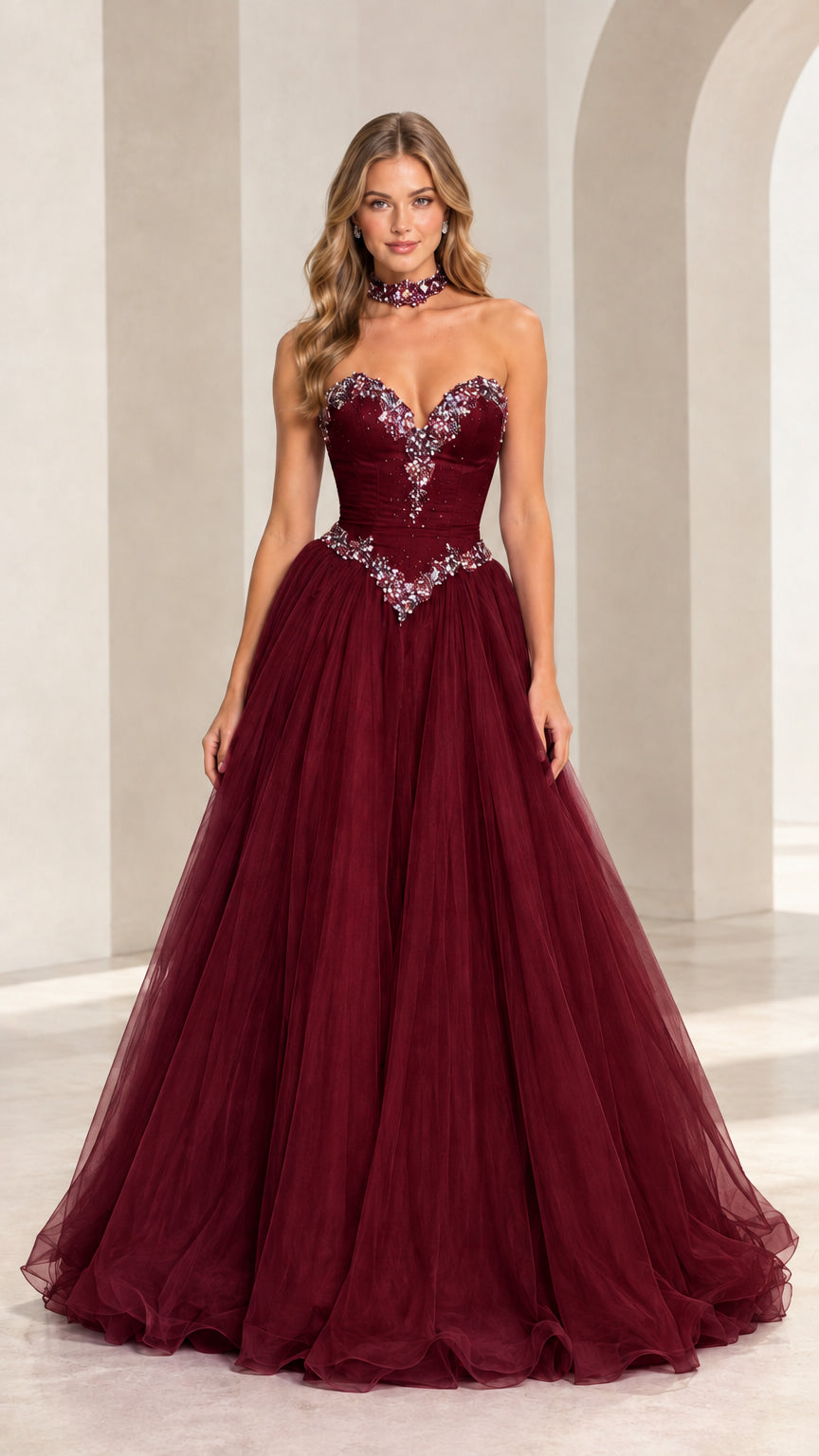 Model wearing burgundy strapless crystal embellished tulle gown