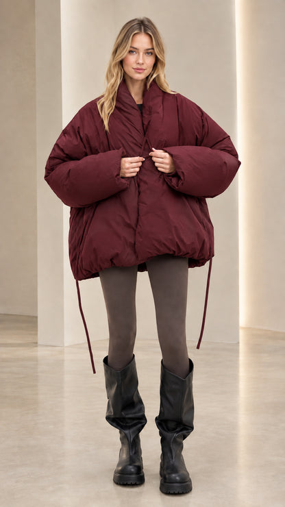 Front view of model wearing burgundy oversized drawstring hem puffer jacket