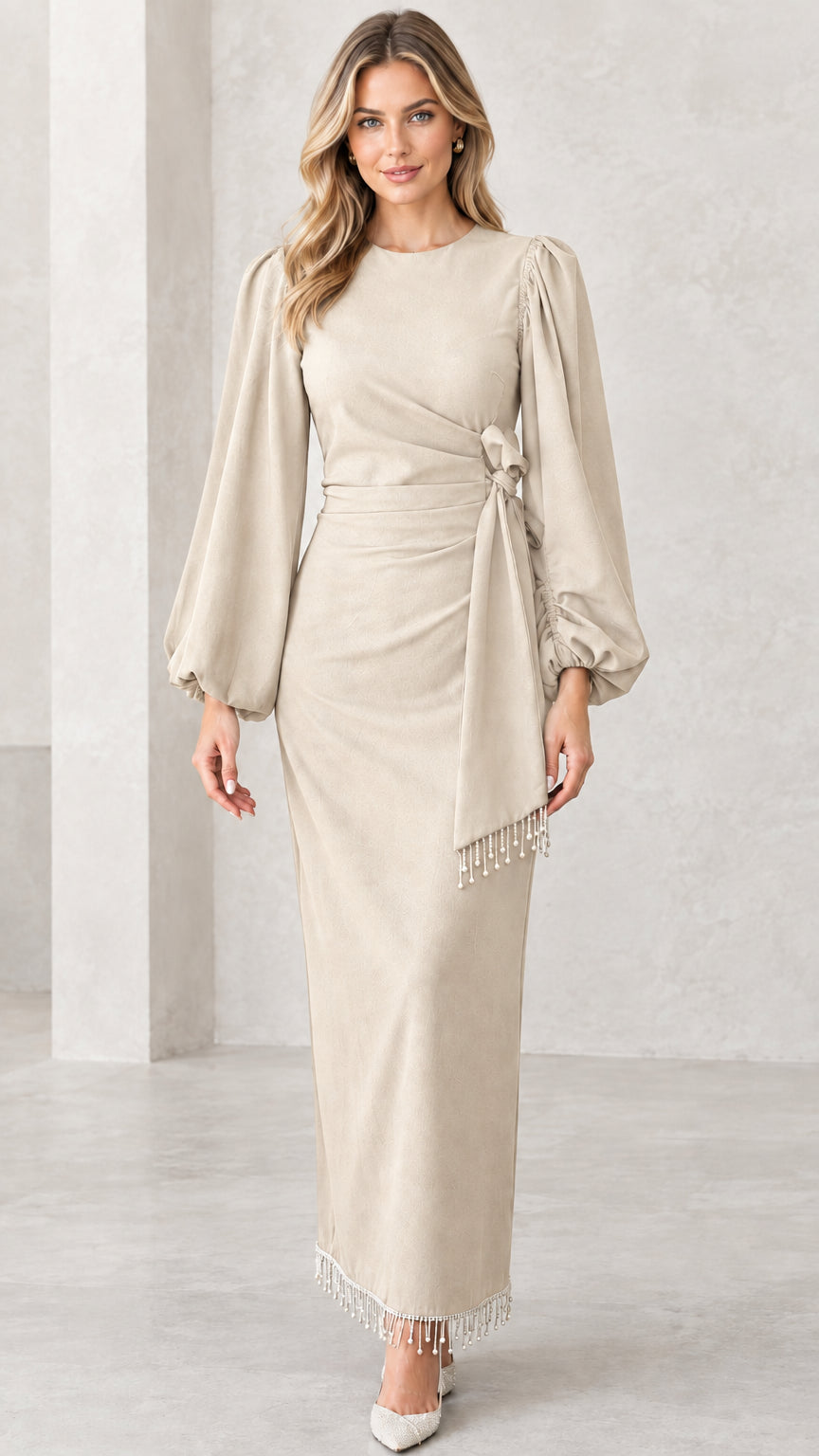 Front view of beige champagne formal draped maxi dress with fringe tassel hem