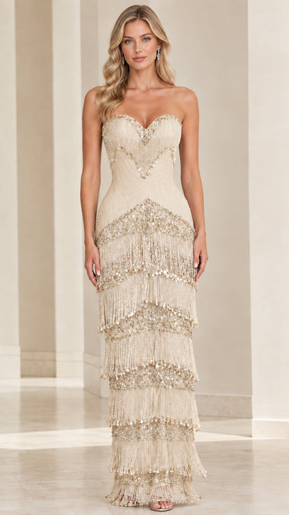 Front view of model wearing champagne gold strapless beaded tiered fringe maxi gown