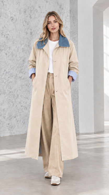 Model wearing classic beige longline trench coat with contrast blue collar