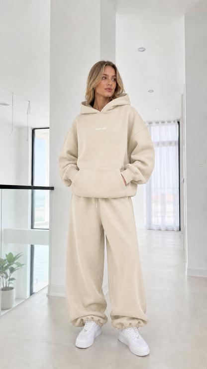 Full-length view of model wearing the cream beige fleece hoodie and sweats set