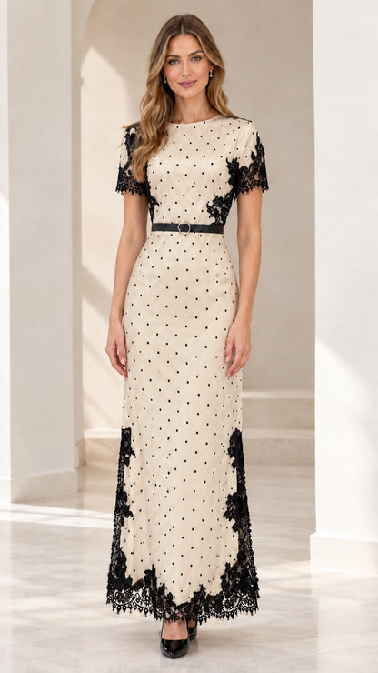 Model wearing beige polka dot maxi dress with black lace trim and belt