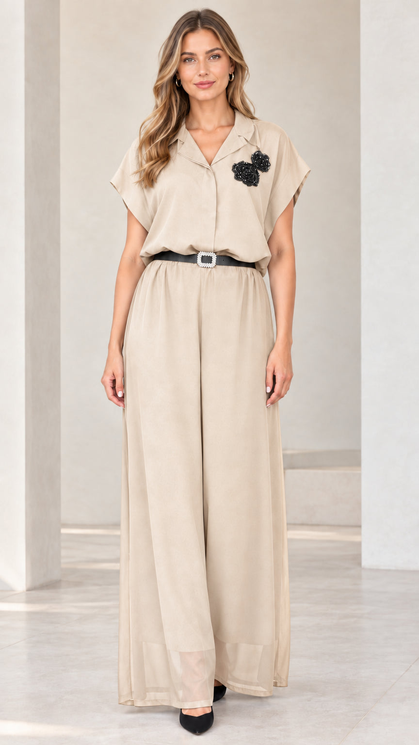Front view of woman wearing beige champagne wide-leg jumpsuit with crystal belt
