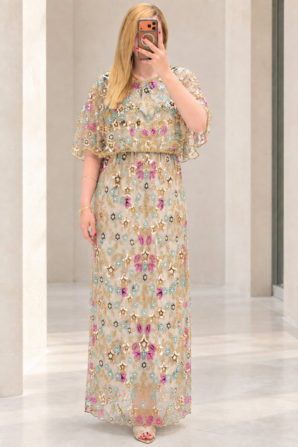Front view of champagne floral sequin embroidered capelet maxi dress
