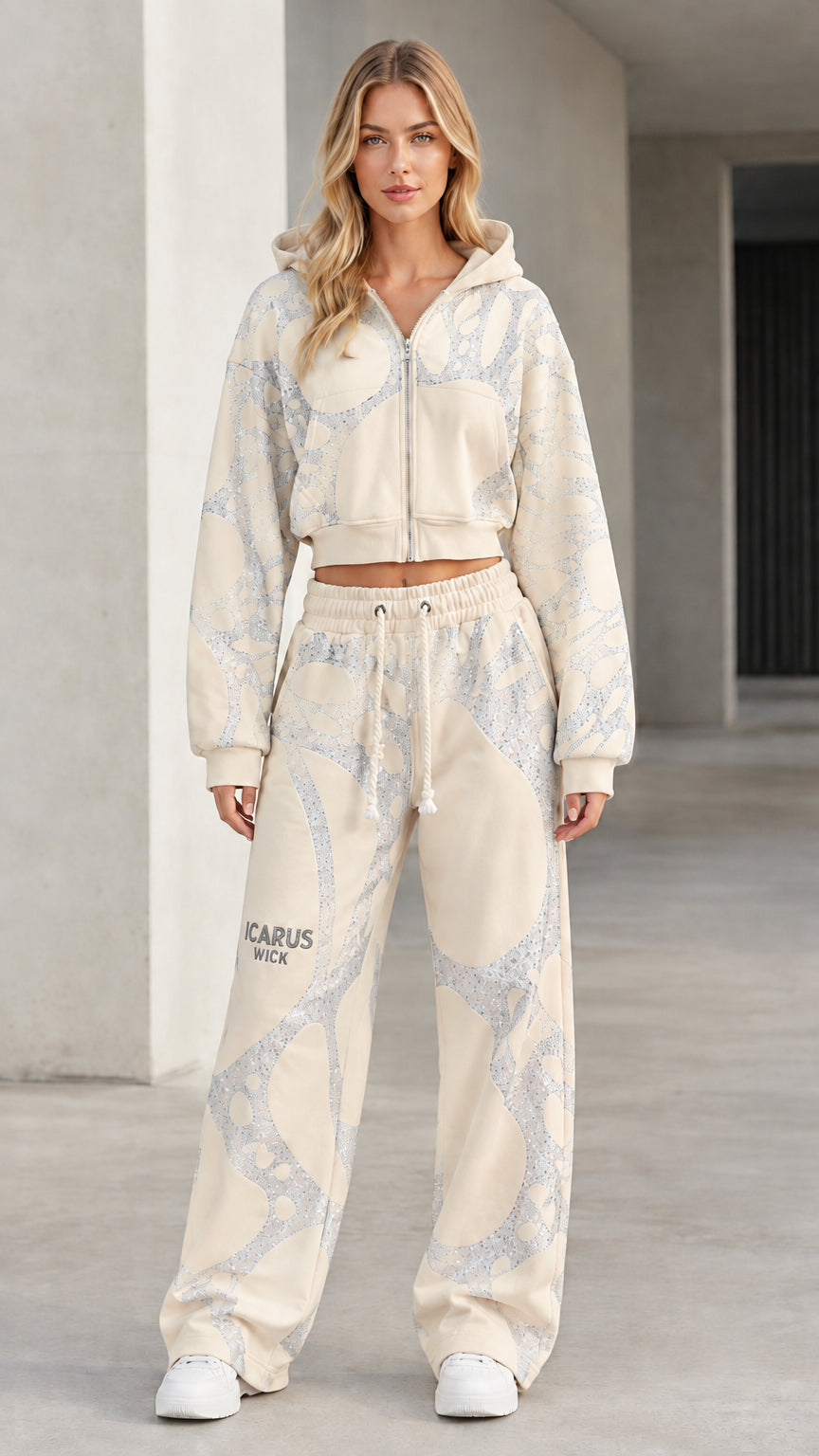 Front view of model wearing beige cream graphic cropped zip hoodie and wide-leg sweatpants