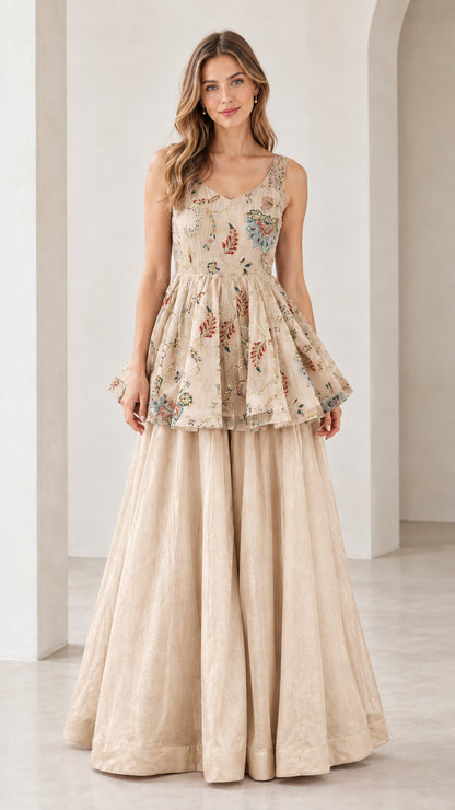 Front view of model wearing champagne beige embroidered peplum top and pants set