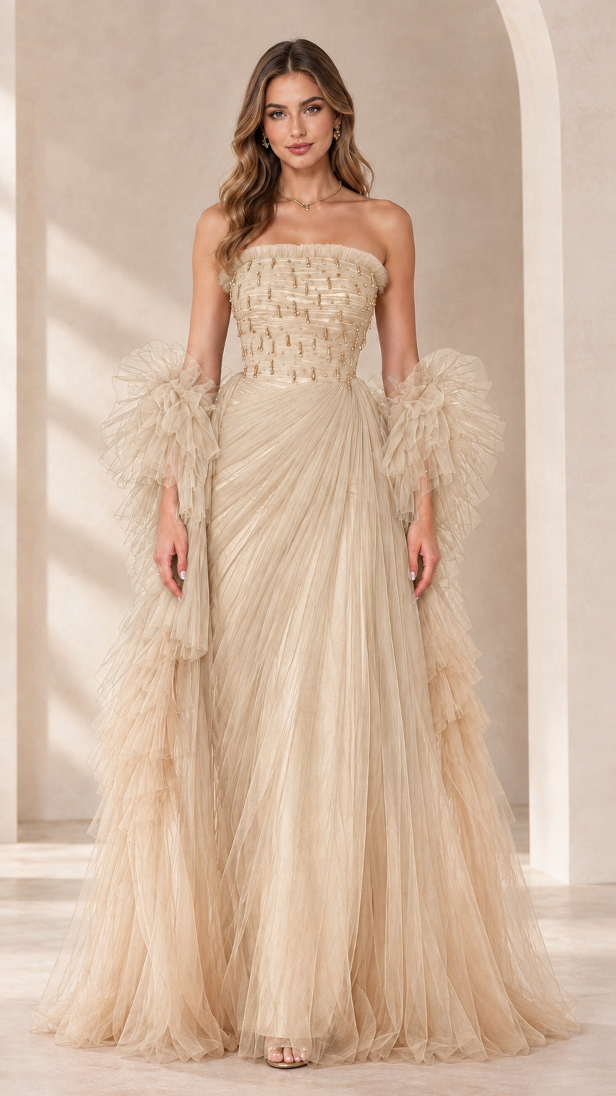 Full-length view of champagne beige strapless beaded tulle evening gown with ruffled sleeve wraps