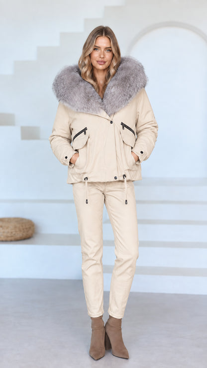Front view of model wearing cream beige faux fur hooded jacket and matching beige pants