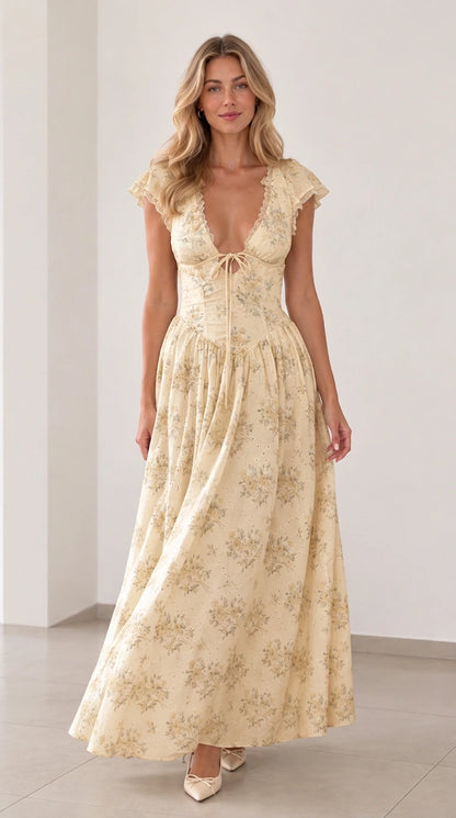 Front view of woman wearing soft yellow floral plunging tie-front maxi dress